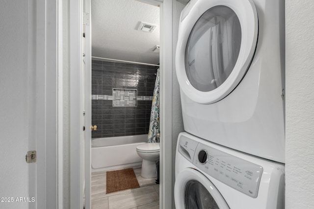 4150 E Cactus Rd Unit 205, Phoenix, AZ 85032 - washroom featuring stacked washing machine and dryer and a textured ceiling