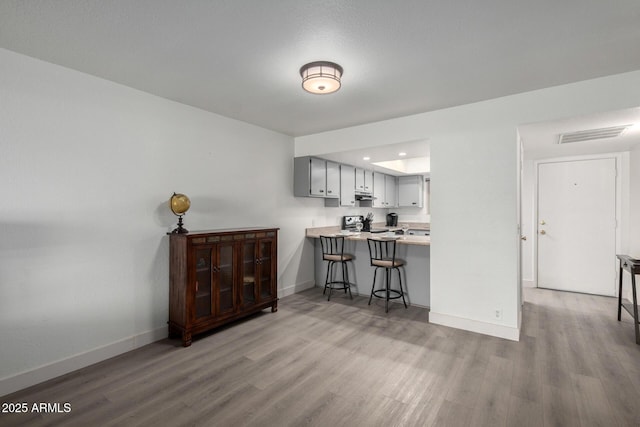 4150 E Cactus Rd Unit 205, Phoenix, AZ 85032 - kitchen featuring a kitchen breakfast bar, light wood-type flooring, range, a peninsula, and recessed lighting