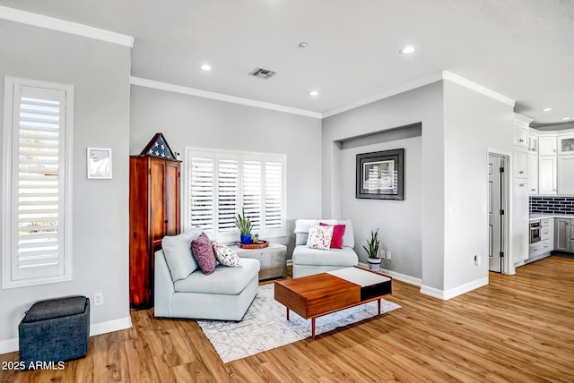 living area with crown molding, visible vents, and plenty of natural light