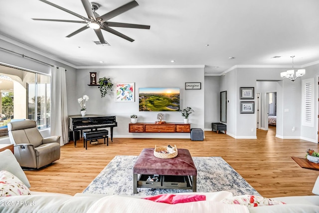 living room featuring ceiling fan with notable chandelier, ornamental molding, wood finished floors, and visible vents