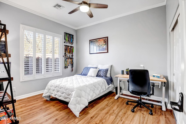 bedroom with ceiling fan, crown molding, and wood-type flooring