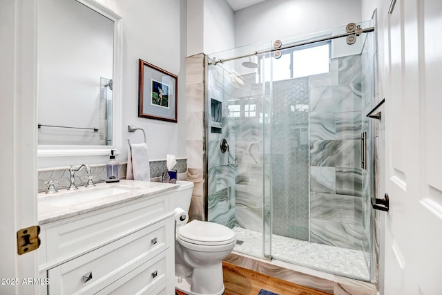 full bathroom featuring vanity, a shower stall, toilet, and tile walls