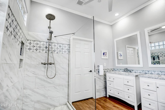 bathroom featuring visible vents, ornamental molding, vanity, wood finished floors, and a walk in shower