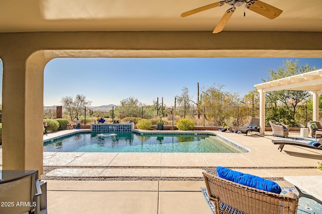 view of swimming pool featuring pool water feature, ceiling fan, a pergola, and a patio