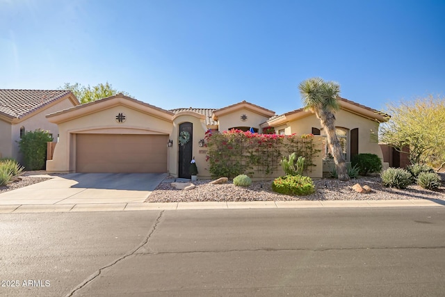 mediterranean / spanish home with a garage, concrete driveway, a tile roof, and stucco siding