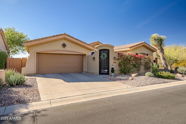 mediterranean / spanish-style home with an attached garage, a tile roof, concrete driveway, and stucco siding