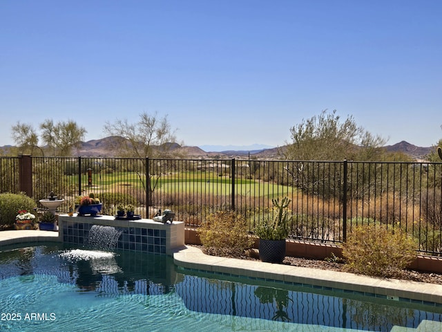 view of swimming pool featuring fence, a mountain view, and a fenced in pool