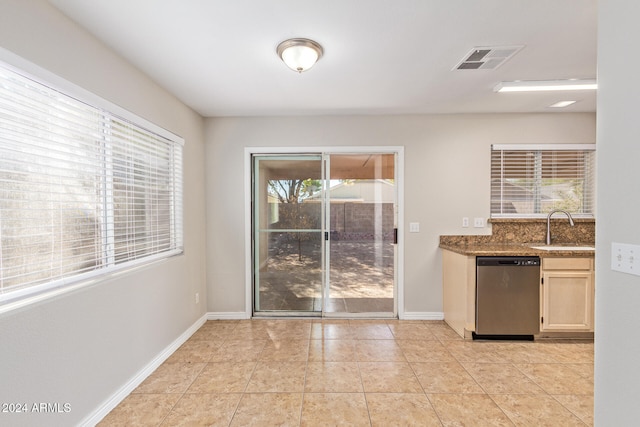 kitchen featuring stainless steel dishwasher, sink, and light tile patterned flooring