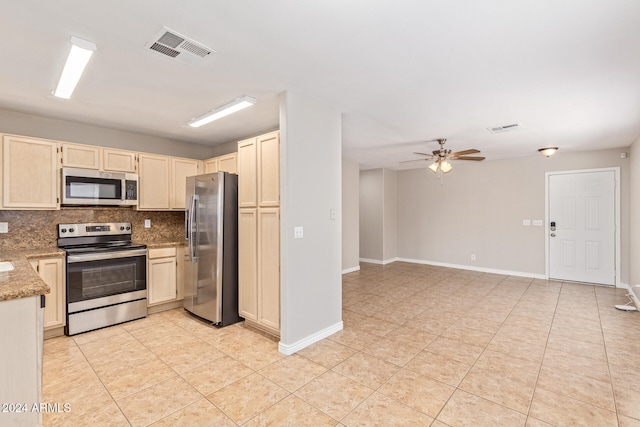 kitchen featuring light stone countertops, appliances with stainless steel finishes, backsplash, and ceiling fan