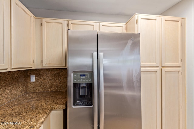 kitchen with light brown cabinets, stainless steel fridge, and tasteful backsplash