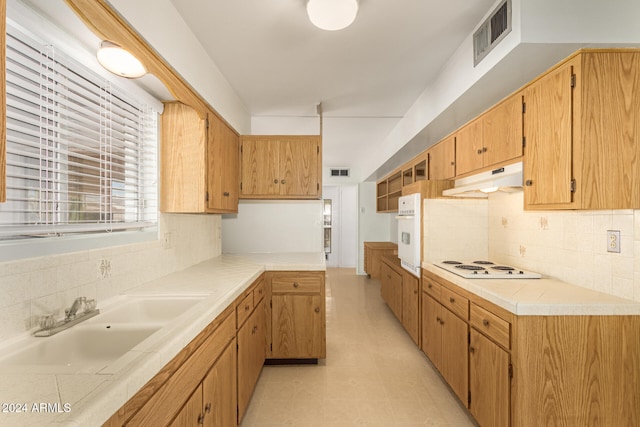 kitchen featuring decorative backsplash, white appliances, sink, and light tile patterned floors