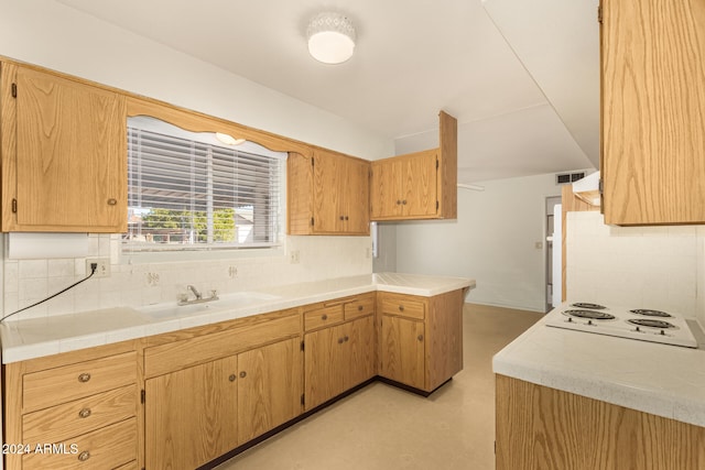 kitchen with tasteful backsplash, white electric cooktop, and sink