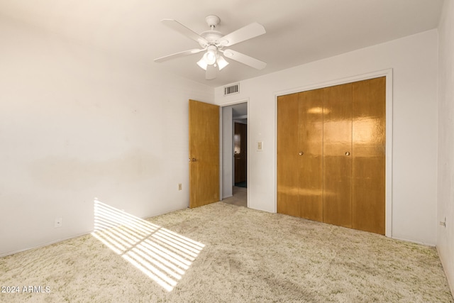 unfurnished bedroom with ceiling fan, a closet, and light colored carpet