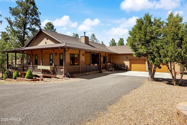 2352 Immelman Cir, Overgaard, AZ 85933 - view of front of property featuring a garage, driveway, a porch, a chimney, and a shingled roof
