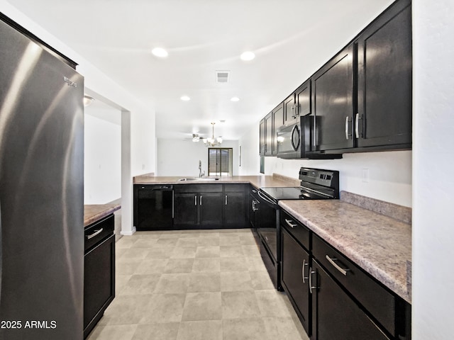 1953 W Stage Driver St, Apache Junction, AZ 85120 - kitchen with black appliances, dark cabinetry, recessed lighting, light countertops, and a chandelier