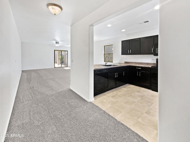 1953 W Stage Driver St, Apache Junction, AZ 85120 - kitchen with black dishwasher, dark cabinets, light carpet, ceiling fan, and light countertops