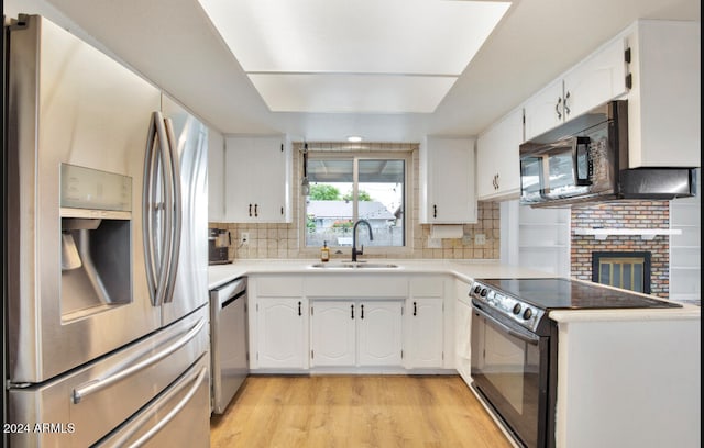 kitchen featuring white cabinets, sink, backsplash, and black appliances