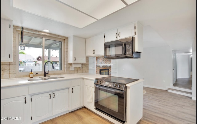 kitchen with black appliances, white cabinetry, sink, and tasteful backsplash