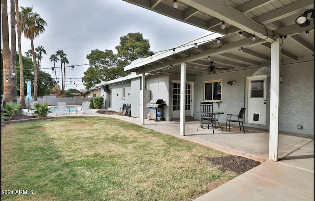 view of yard featuring ceiling fan and a patio