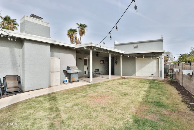 rear view of house with a patio area, a yard, and a garage