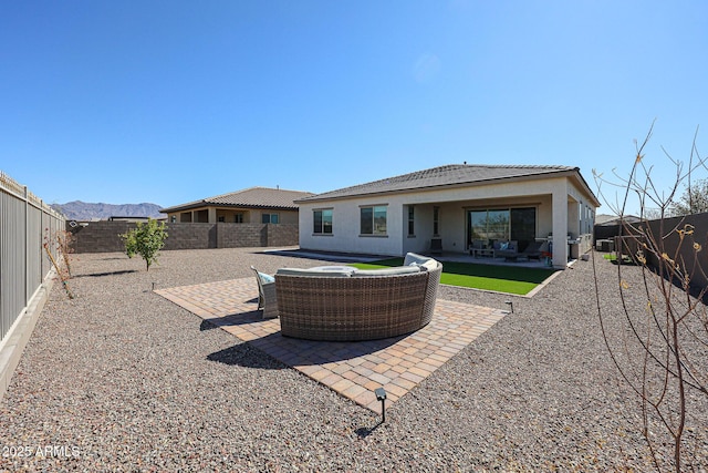 rear view of house featuring stucco siding, a fenced backyard, a patio, and a mountain view