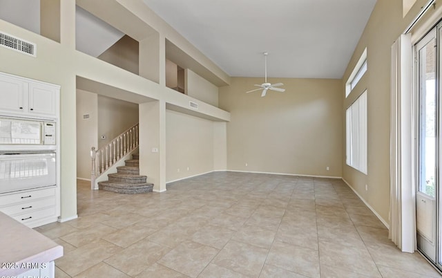 6923 W Laredo St, Chandler, AZ 85226 - unfurnished living room with a ceiling fan, stairs, high vaulted ceiling, and light tile patterned floors