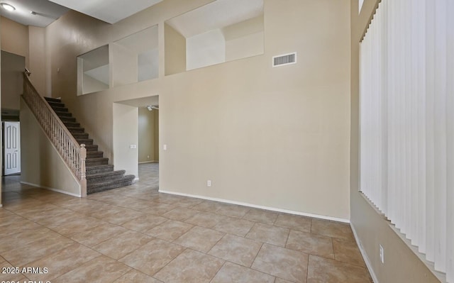 6923 W Laredo St, Chandler, AZ 85226 - unfurnished room with a towering ceiling, stairs, and tile patterned floors
