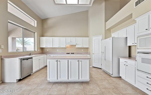 6923 W Laredo St, Chandler, AZ 85226 - kitchen featuring white appliances, high vaulted ceiling, under cabinet range hood, light countertops, and a kitchen island