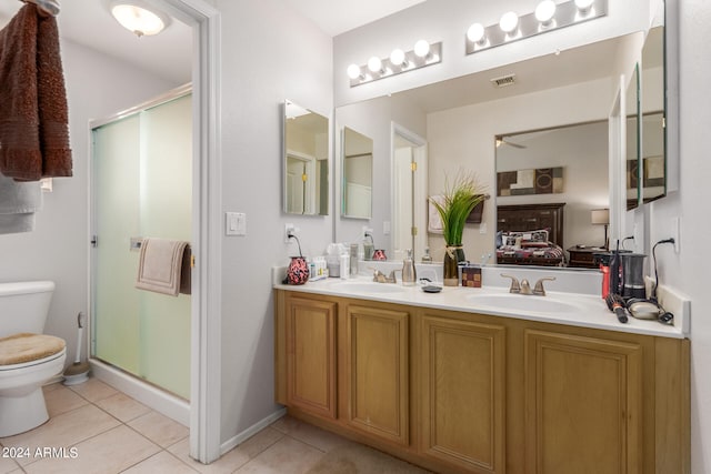 bathroom with tile patterned flooring, toilet, double sink vanity, and a shower with shower door