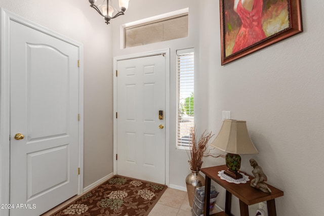 foyer entrance with light tile patterned floors and an inviting chandelier