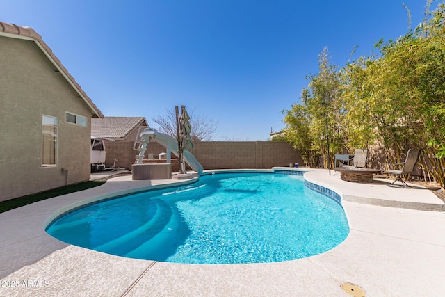 view of swimming pool with a fire pit, a fenced backyard, and a patio area