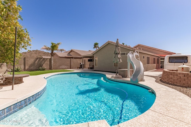 view of pool with a fenced in pool, a patio, a water slide, and a fenced backyard