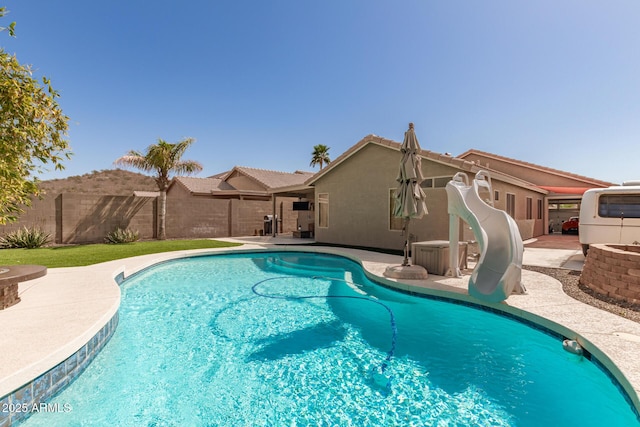 view of pool featuring a fenced in pool, fence, a water slide, and a patio area