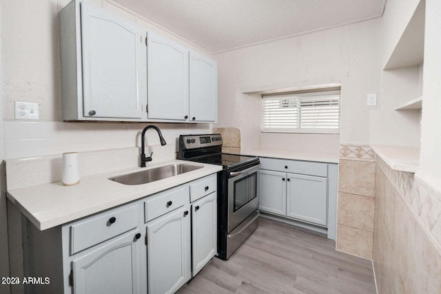 kitchen featuring gray cabinets, tile walls, electric stove, light hardwood / wood-style floors, and sink