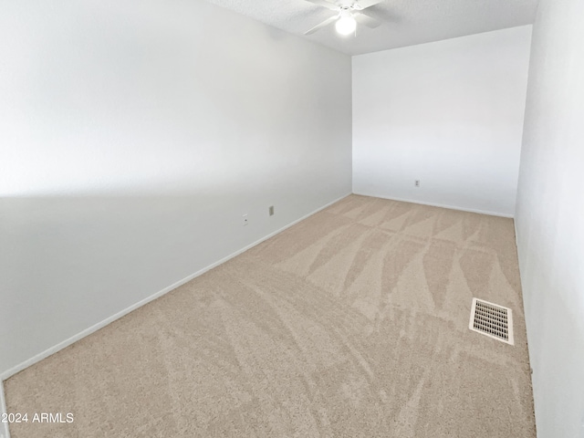 carpeted empty room with a ceiling fan, visible vents, and a textured ceiling