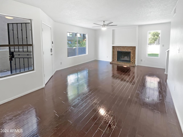 unfurnished living room with hardwood / wood-style floors, plenty of natural light, and a textured ceiling