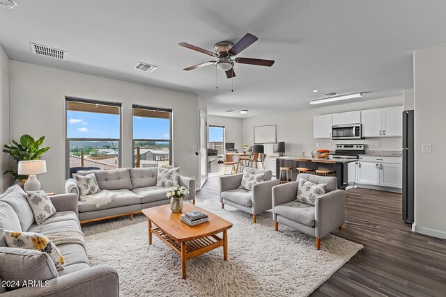 living room featuring ceiling fan and dark hardwood / wood-style floors