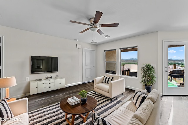 living room featuring ceiling fan and dark hardwood / wood-style flooring