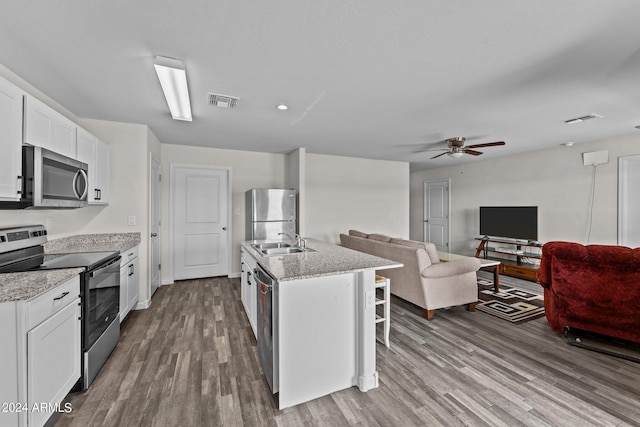 kitchen featuring sink, white cabinetry, appliances with stainless steel finishes, an island with sink, and hardwood / wood-style flooring