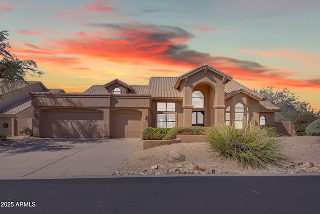 12605 E Kalil Dr, Scottsdale, AZ 85259 - mediterranean / spanish house featuring an attached garage, stucco siding, driveway, and a tiled roof