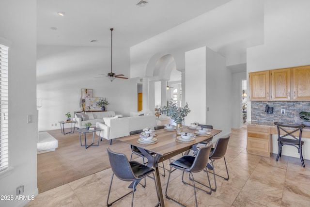 12605 E Kalil Dr, Scottsdale, AZ 85259 - dining room featuring a ceiling fan, arched walkways, decorative columns, a towering ceiling, and light tile patterned floors