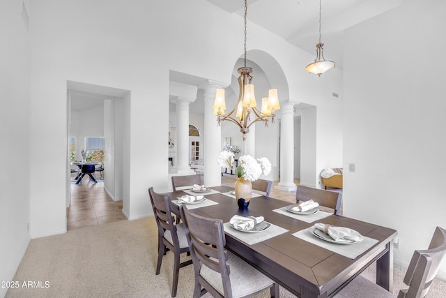 12605 E Kalil Dr, Scottsdale, AZ 85259 - dining area with decorative columns, a towering ceiling, a chandelier, light carpet, and arched walkways