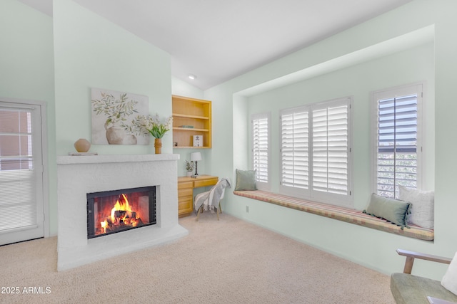 12605 E Kalil Dr, Scottsdale, AZ 85259 - living area featuring a lit fireplace, lofted ceiling, healthy amount of natural light, and carpet flooring