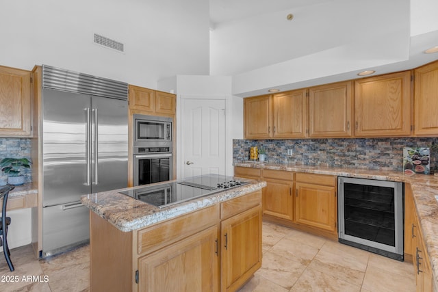12605 E Kalil Dr, Scottsdale, AZ 85259 - kitchen featuring built in appliances, wine cooler, a center island, a towering ceiling, and backsplash