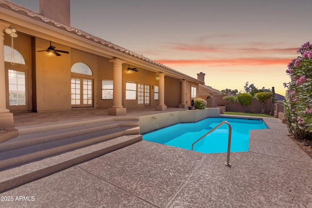 12605 E Kalil Dr, Scottsdale, AZ 85259 - pool at dusk with french doors, a patio area, a ceiling fan, and a fenced backyard