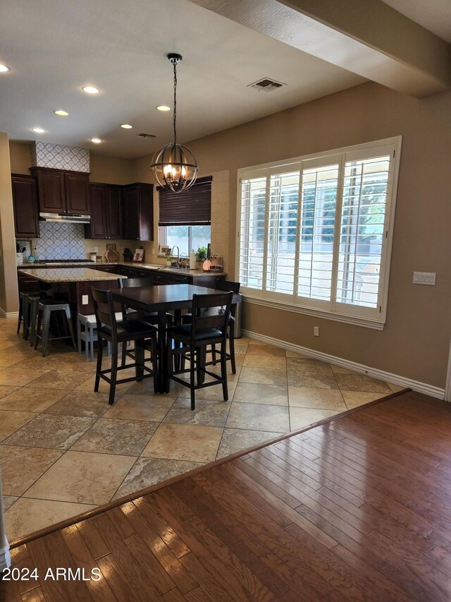 dining area with sink, light hardwood / wood-style flooring, and a chandelier