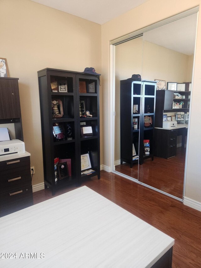 home office with dark wood-type flooring