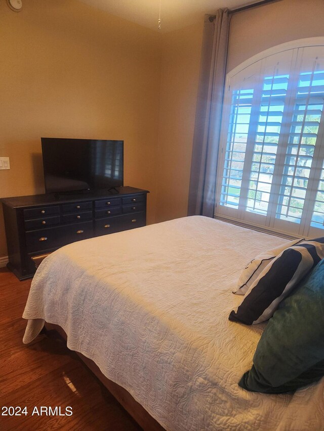 bedroom with dark wood-type flooring