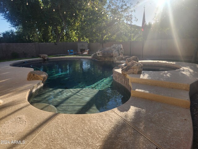 view of pool featuring a patio area and an in ground hot tub