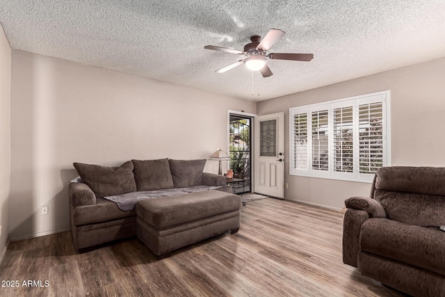 living room with hardwood / wood-style floors, a textured ceiling, and ceiling fan